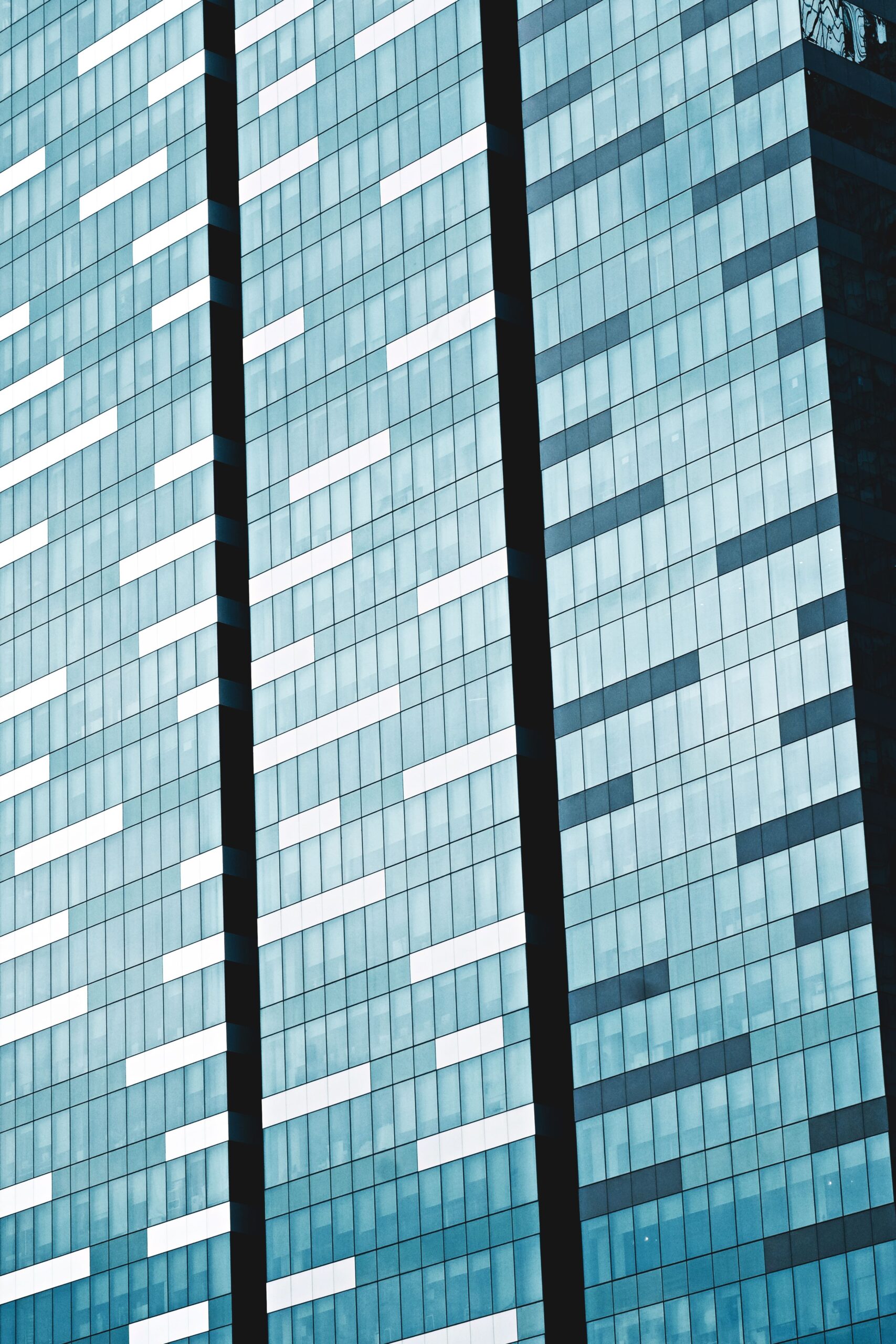 Close-up of a modern skyscraper's glass facade in Singapore, showcasing architectural patterns and reflections.